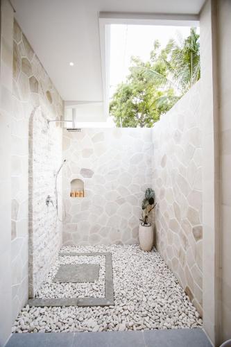 a bathroom with a walk in shower and a window at Bukti Garden Villas in Bukti