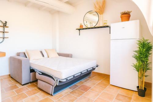 a bed in a room with a refrigerator at Le Nily Provence, douceur & vue d'exception in Sainte-Tulle
