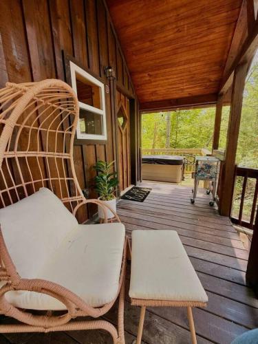 a porch with a rattan chair on a wooden deck at Adventurer's Nook in High Falls
