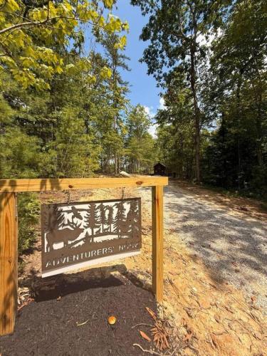 a sign on a dirt road with trees in the background at Adventurer's Nook in High Falls