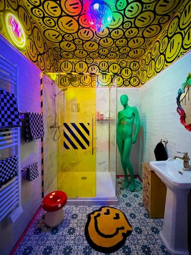 a bathroom with a sink and a shower with a green man at Le Loft des Cévennes in Ganges