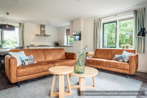 a living room with a couch and a table at Bungalowpark 't Hoogelandt in De Koog