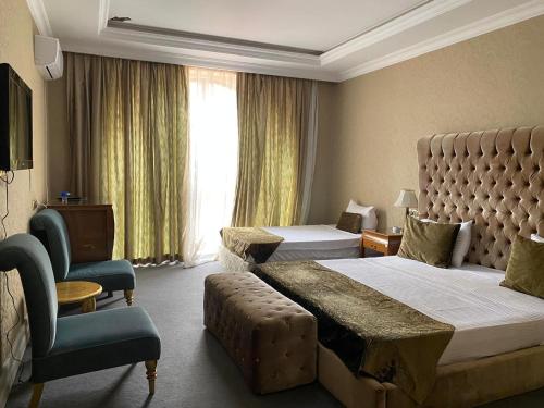 a hotel room with two beds and a chair at Lake view Palace Hotel in Baku