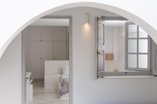 AgkidiaPhilia villas的通往卧室的拱门，卧室里有一面镜子。