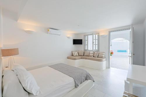 AgkidiaPhilia villas的一间带床和沙发的白色卧室