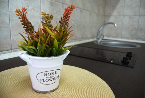 a vase with flowers in it sitting on a table at Contessa Apartment Cluj Napoca in Cluj-Napoca