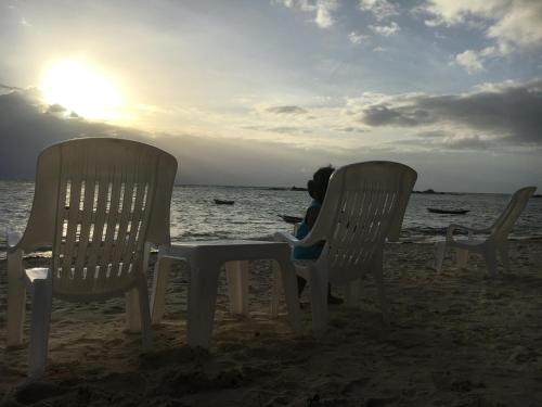 a child sitting in a chair on the beach at Jungle Hut Bungalows & Hotel in Haad Chao Phao