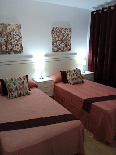 a hotel room with two beds and two lamps at La Esperanza Apartaments in La Esperanza