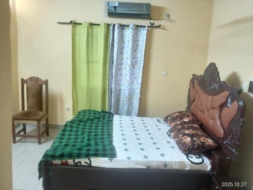 Un dormitorio con una cama y una cortina verde. en Bobo LAFIA RESIDENCE MEUBLEE, en Bobo-Dioulasso