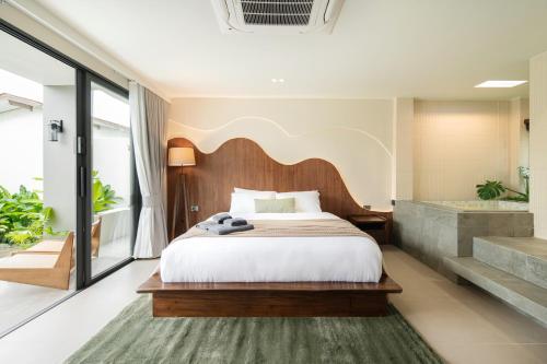 a bedroom with a large bed and a bathroom at naravi gardenandpool kohlarn in Ko Sak