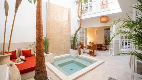 ein Pool mitten in einem Wohnzimmer mit Palmen in der Unterkunft Riad Dar Zioui in Marrakesch