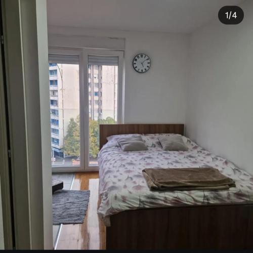 a bedroom with a bed and a clock on the wall at Dream House Zvornik in Zvornik