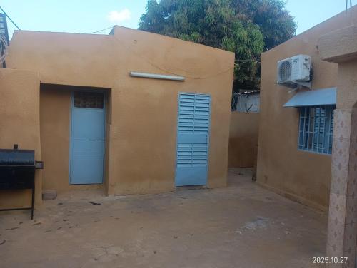 un edificio con dos puertas azules y un ventilador en Bobo LAFIA RESIDENCE MEUBLEE, en Bobo-Dioulasso