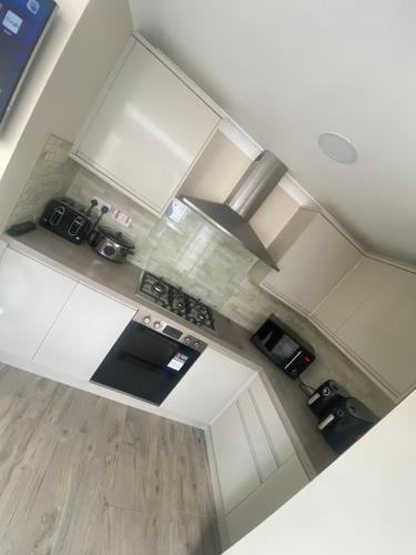 an overhead view of a kitchen with white cabinets at Cozy En-suit by nec & airport in Marston Green