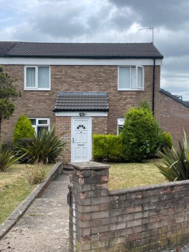 a house with a white door and a brick fence at Cozy En-suit by nec & airport in Marston Green