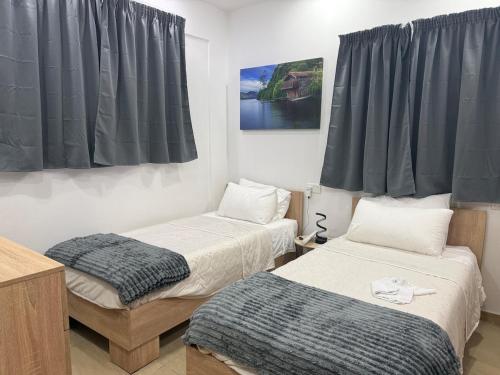 two beds in a room with black curtains at 4 Bed Maisonette Close to Mater Dei in Birkirkara