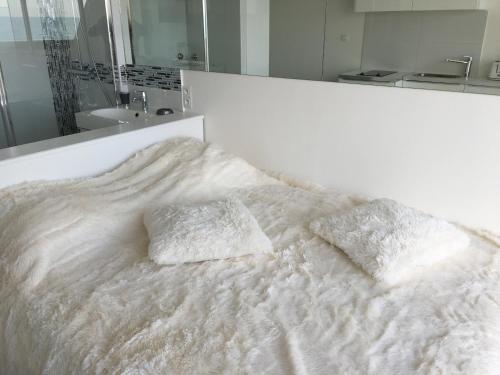 - un lit blanc avec 2 oreillers dans l'établissement Studio face Mer - Village Naturiste - Cap d'Agde, au Cap d'Agde