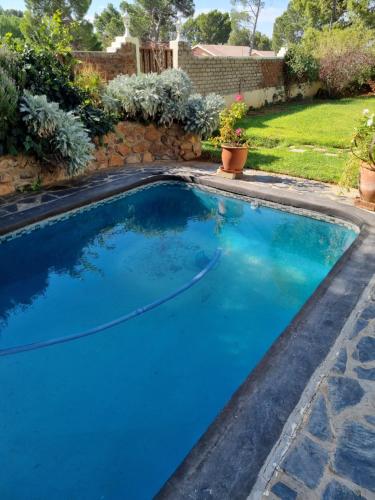 a swimming pool with blue water in a yard at Serene Haven Guest House in Victoria West