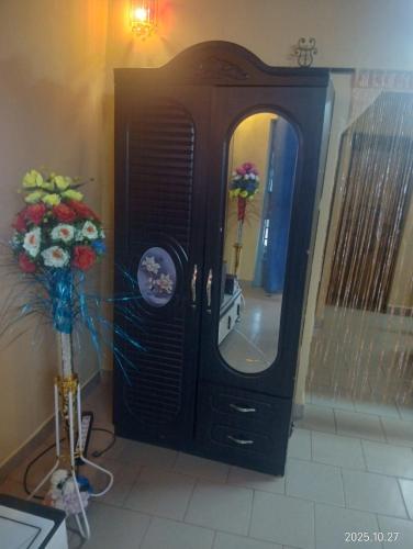 a dresser with a mirror in a room with flowers at RESIDENCE MEUBLEe BOBO LAFIA in Bobo-Dioulasso