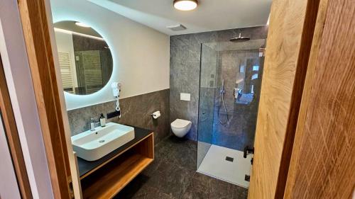 Un baño con lavabo y ducha en Hotel Krone, en Morter