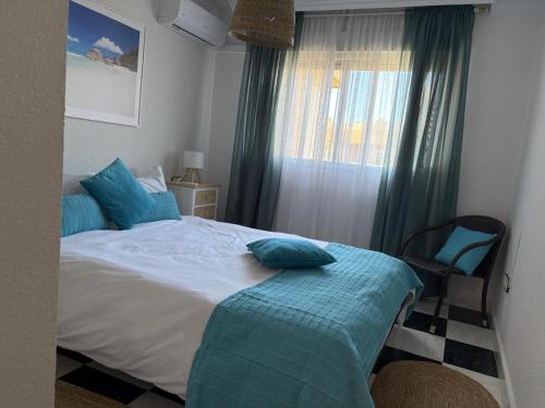 een slaapkamer met een bed met blauwe kussens erop bij ATICO AMBERES SEAVIEW PENTHOUSE - Torrox Costa in Castillo Bajo