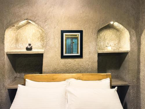 Postel nebo postele na pokoji v ubytování بيت الصباح نزل وكافيه Bait AlSabah Heritage Inn & Cafe