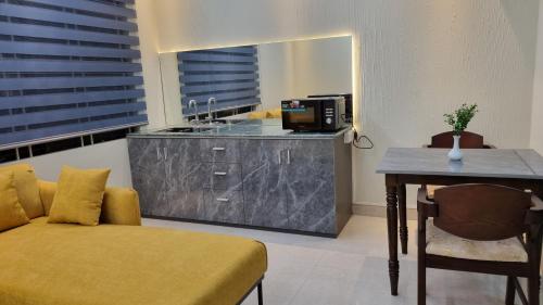 una cucina con un divano e un tavolo in una stanza di Royal Crest a Dhaka