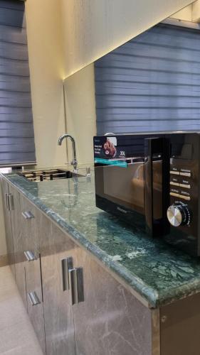 una cucina con un piano di lavoro con un forno a microonde di Royal Crest a Dhaka
