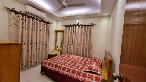 una camera da letto con un letto, tende e una porta di Royal Crest a Dhaka