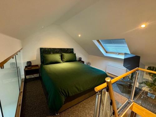 a bedroom with a green bed and a window at Boutique Spa apartment with Balcony & River Views in Norwich