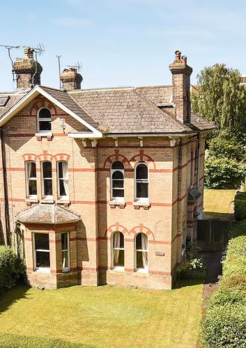 an old brick house with windows and a roof at Large 2 bedroom town centre top floor flat with free parking in Dorchester