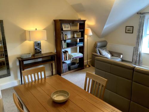 a living room with a table and a couch at Large 2 bedroom town centre top floor flat with free parking in Dorchester