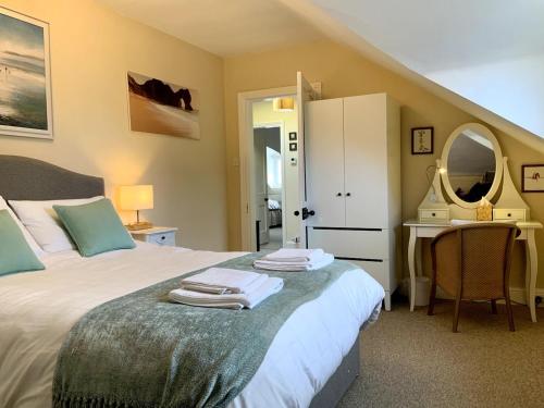 a bedroom with a bed and a desk and a mirror at Large 2 bedroom town centre top floor flat with free parking in Dorchester