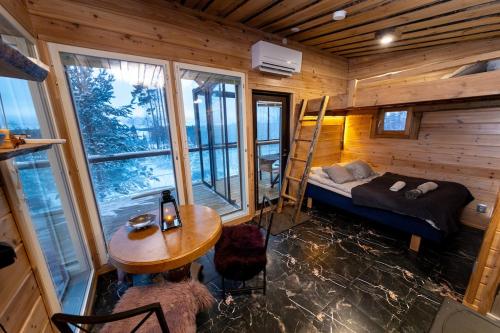 a room with a bed and a table in a cabin at Kalliomaja Villa Lummelahti in Savitaipale
