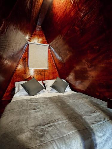 a bedroom with a bed in a wooden room at Chalé mirante do Sol in Socorro