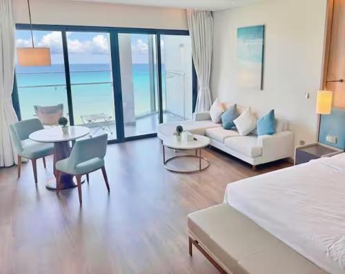 une chambre d'hôtel avec un lit, un canapé et des tables dans l'établissement Seaview Quy Nhon apt TMS, à Quy Nhơn