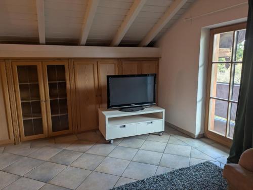 a living room with a television on a white cabinet at Idyllische Maisonettewohnung mit Bergblick in Irschenberg