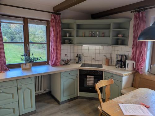 a kitchen with mint green cabinets and a table and a table sidx sidx at Idyllische Maisonettewohnung mit Bergblick in Irschenberg