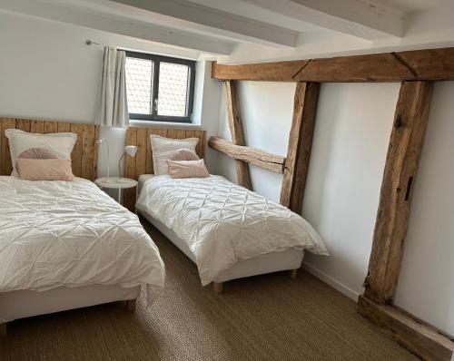 2 Einzelbetten in einem Zimmer mit 2 Fenstern in der Unterkunft Corps de ferme alsacien in Grassendorf