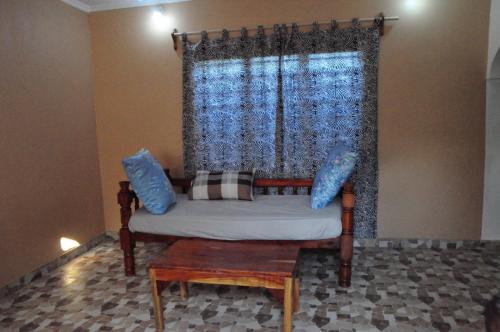 a couch sitting in a room with a window at Bulu Apartments in Kilifi