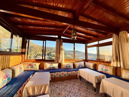 a room with couches and windows in a building at Hôtel Koutoubia in Chefchaouen