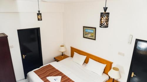 a bedroom with a bed and two lamps and lights at PAN Hotel Apartments in Sharjah