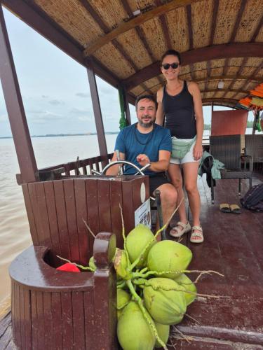 a man and a woman sitting on a boat at Homestay Xóm Quê in Ấp Thành Hòa