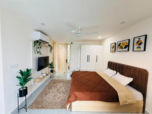 ein Schlafzimmer mit einem Bett und einem Fernseher darin in der Unterkunft Cozy Studio with Private Terrace & Golf Course View Road in Gurgaon