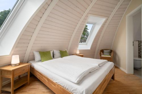 a bedroom with a large bed in an attic at Nordkugel - Rundes Wohnglück am Tollensesee in Wustrow