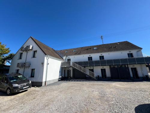 ダージングにあるSmart Wohnen Dasingの前に車が駐車されている白い家