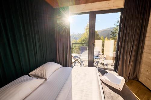 a bedroom with a bed and a balcony with a view at Blog House Resort in Yaremche