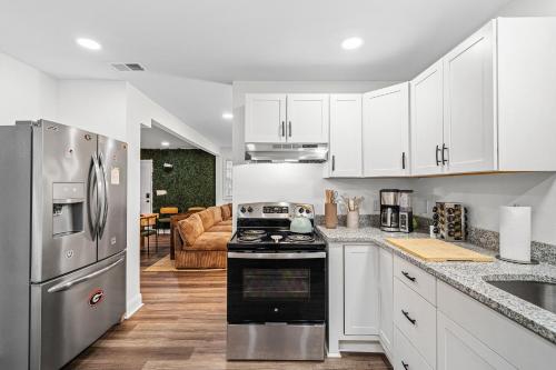 a kitchen with white cabinets and a stove top oven at 2 King Beds Cozy Athens GA Getaway in Athens