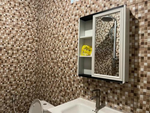 龙目岛库塔Sakila Guest House的浴室里有洗手池和镜子