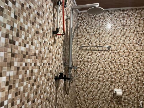 eine Dusche im Bad mit einer gefliesten Wand in der Unterkunft Hotel Florida Mandalika Lombok in Kuta Lombok